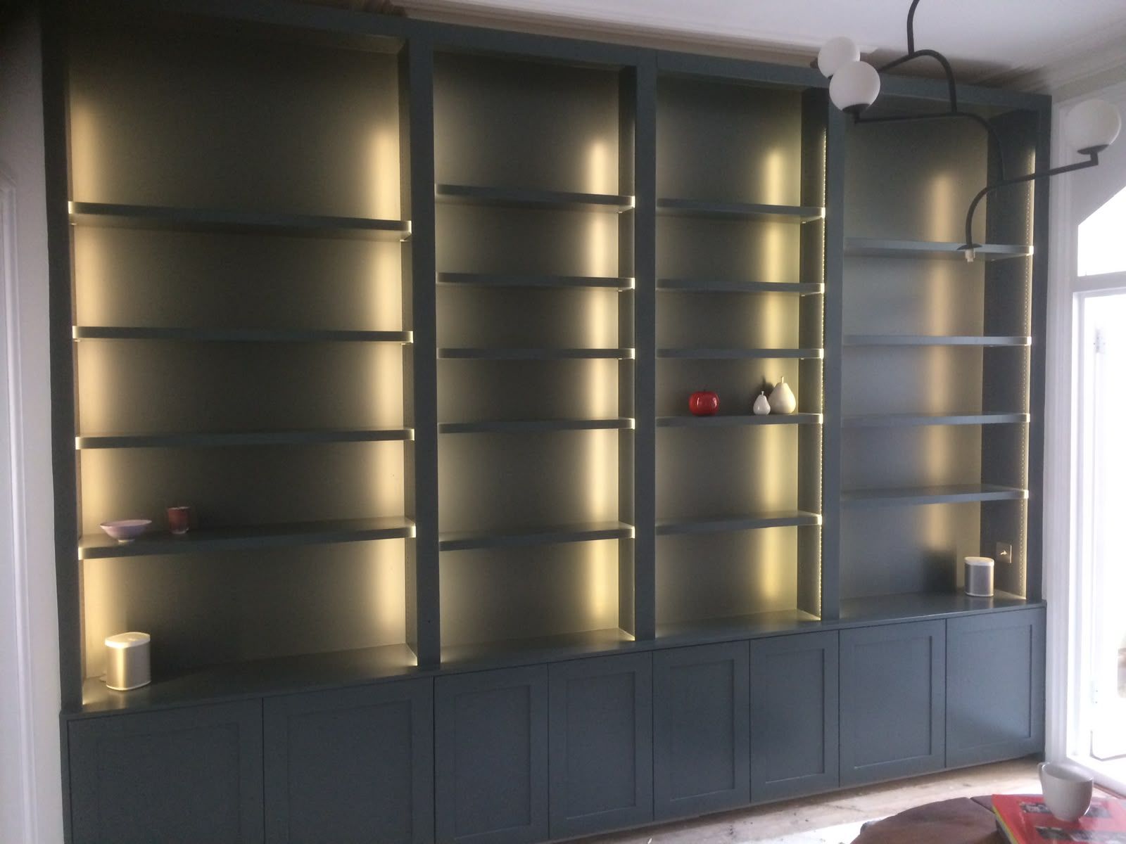 Bespoke fitted bookcase with integrated shelf lighting, built by PJ Joinery