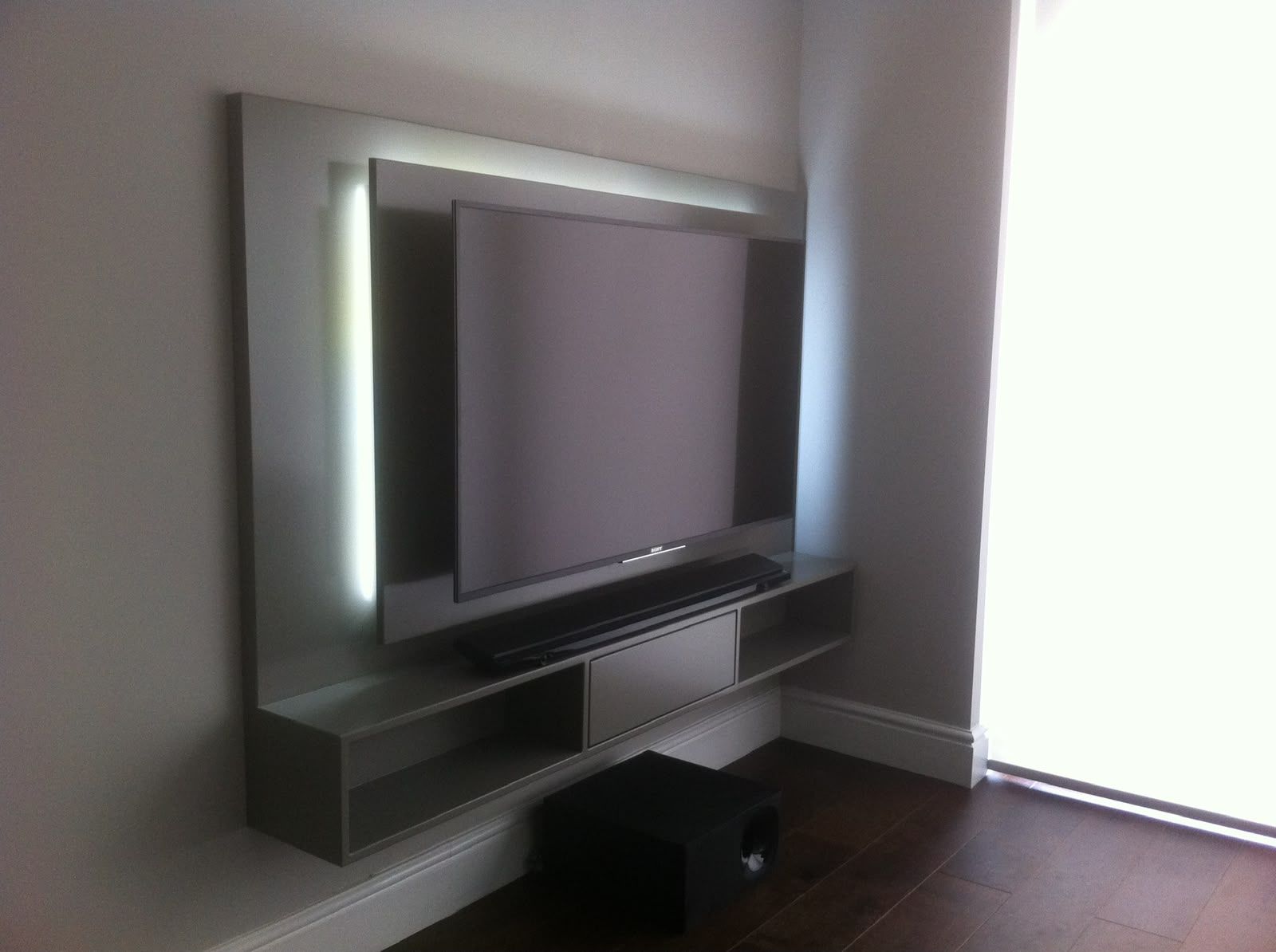 Backlit fitted media wall with recessed lighting